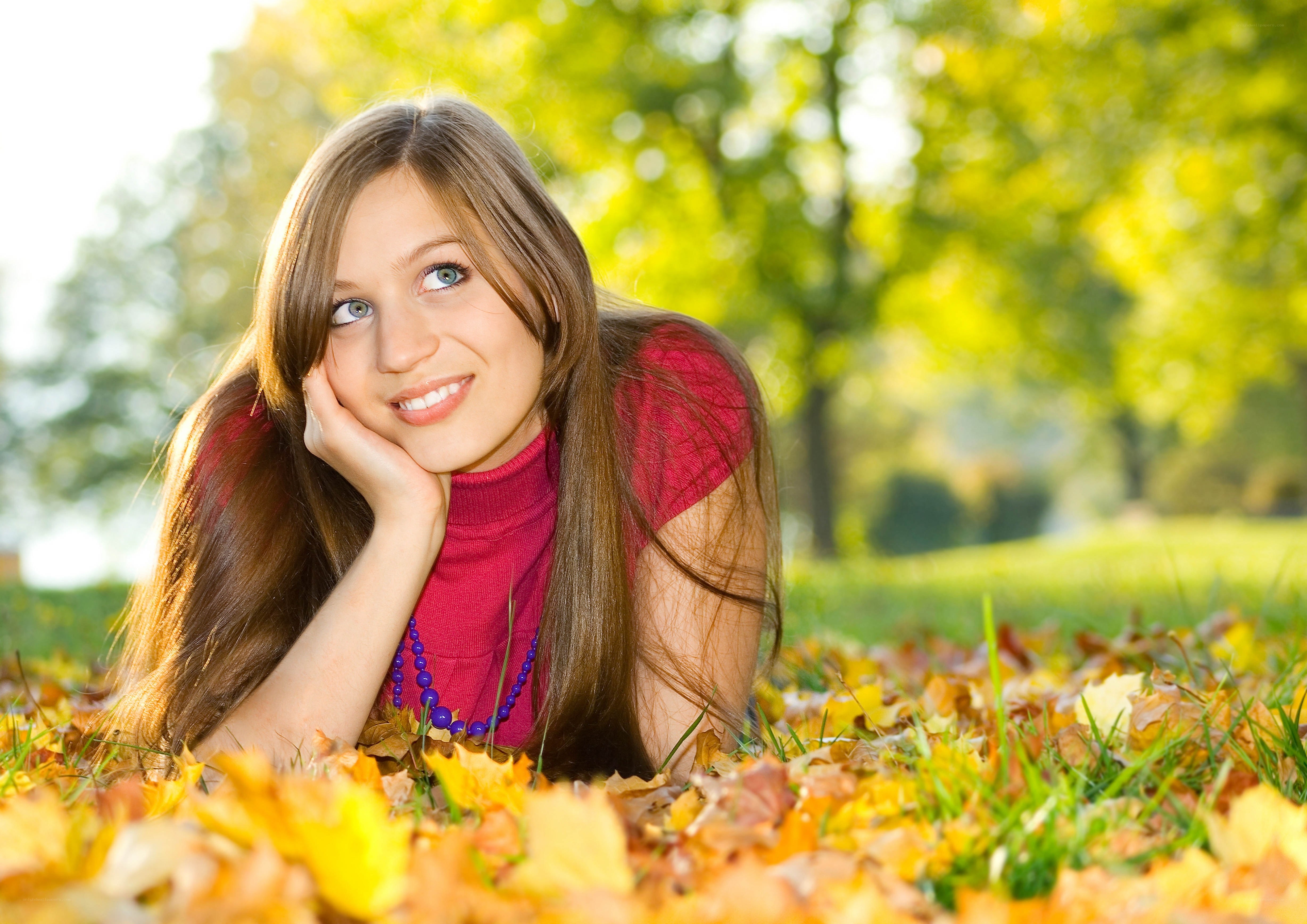 woman lying in autumn leaves