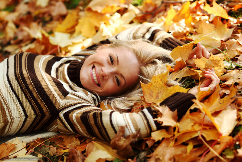 woman lying in autumn leaves