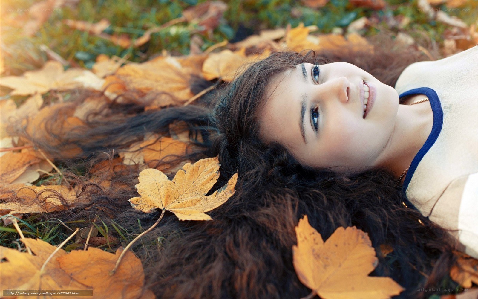 Woman lying in autumn leaves