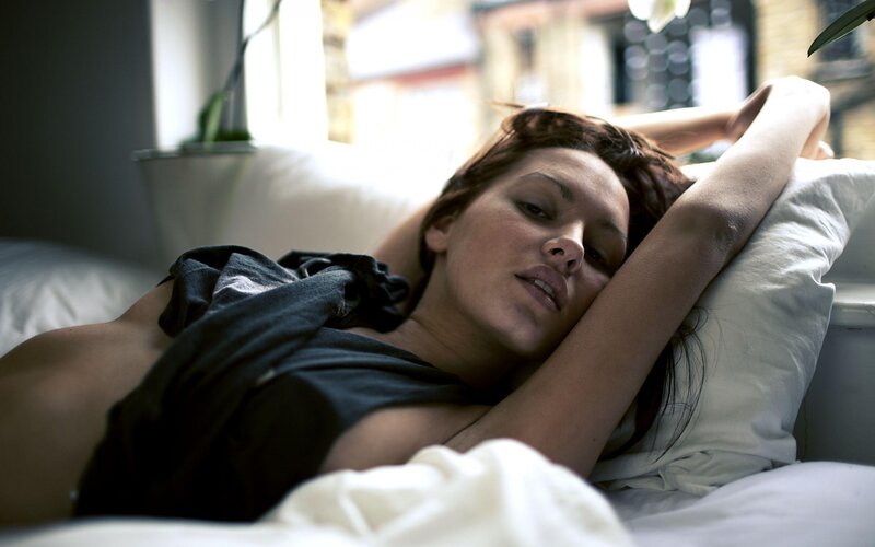 woman lying in bed stretching