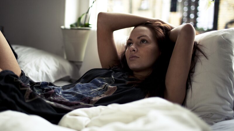 woman lying in bed thinking