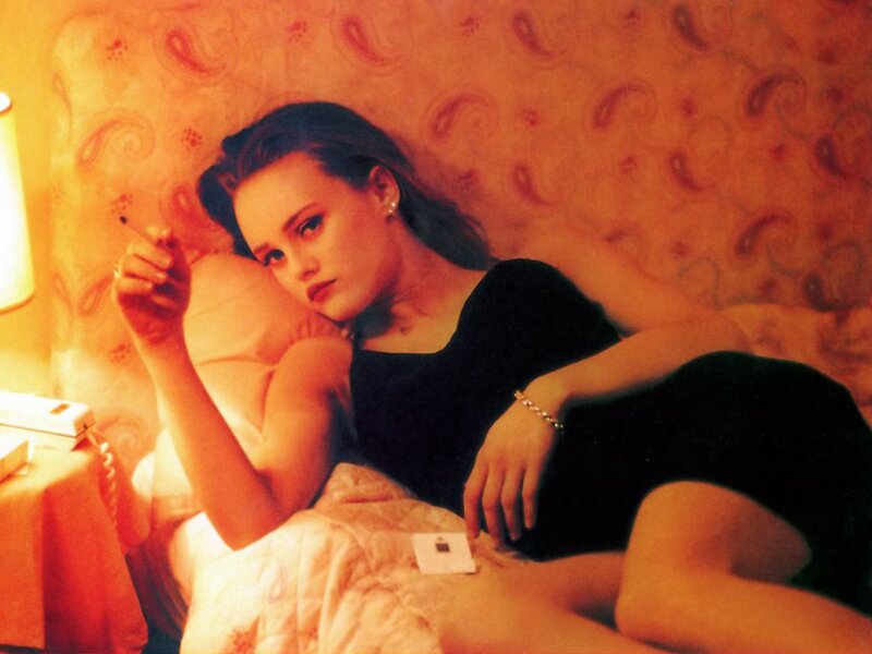 woman lying in bed with cigarette