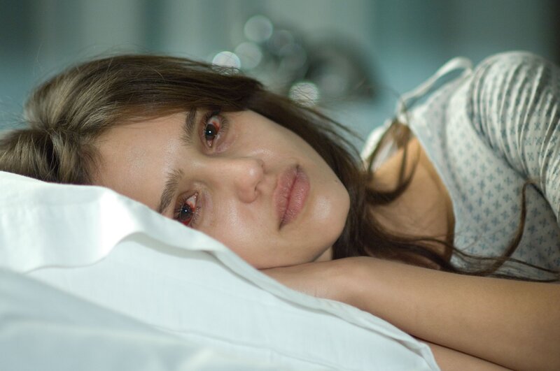 woman lying in bed with red eyes
