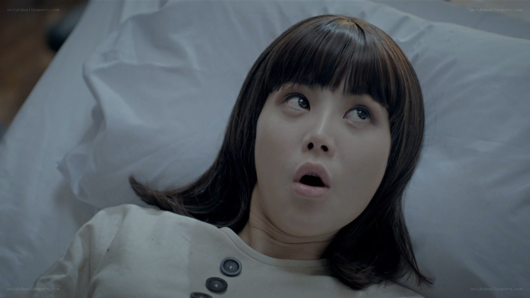 woman lying in bed with shocked expression
