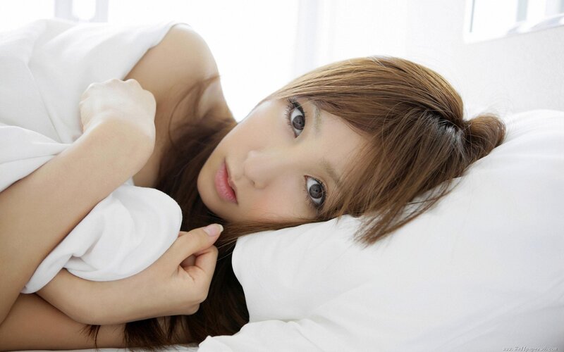woman lying in bed with white pillow