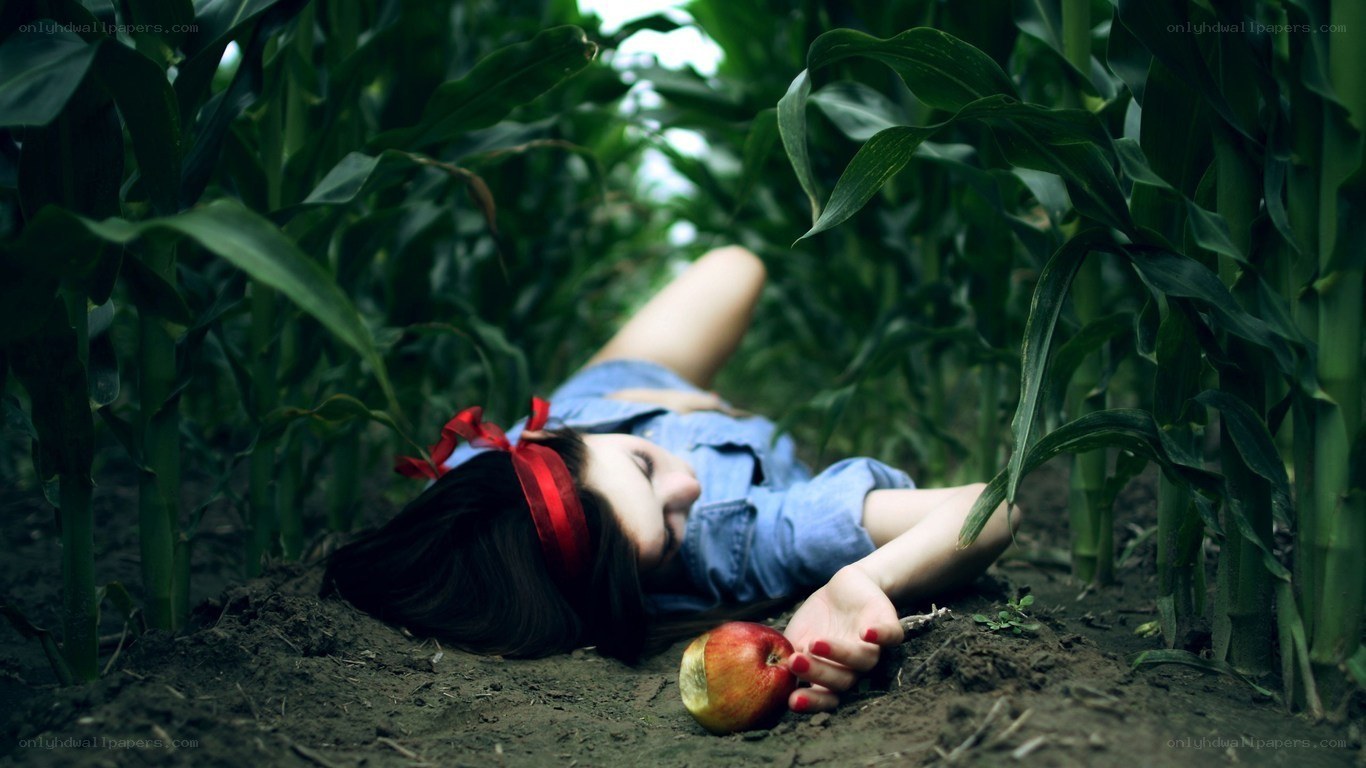 woman lying in cornfield with apple