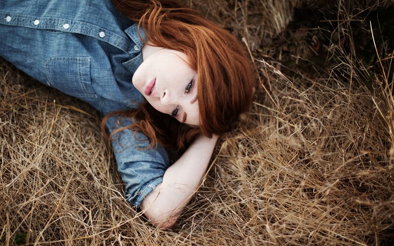 woman lying in dry grass