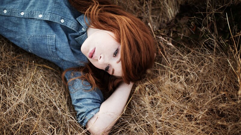 woman lying in dry grass