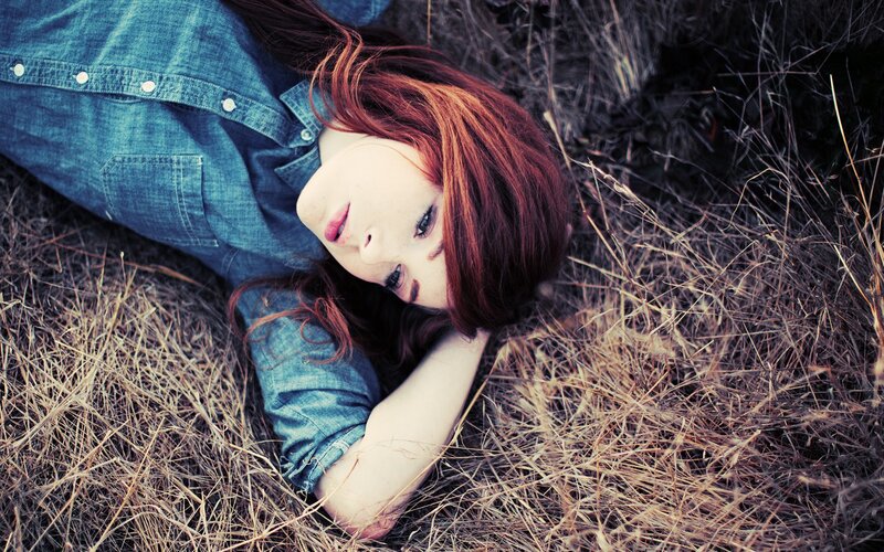woman lying in dry grass