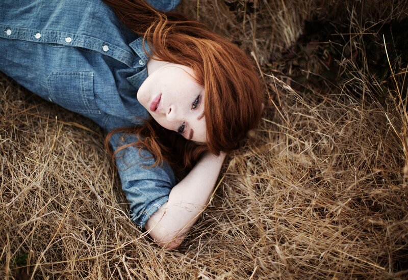 woman lying in dry grass