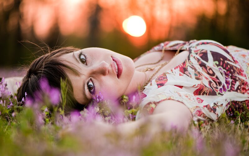 woman lying in field at sunset