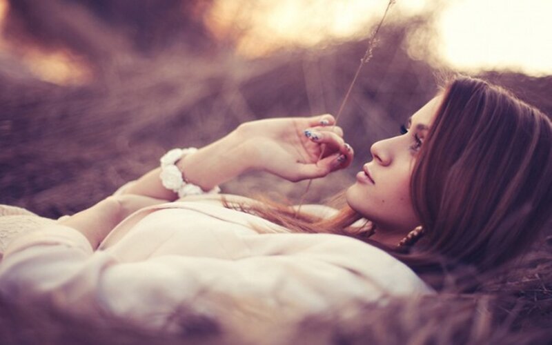 woman lying in field at sunset