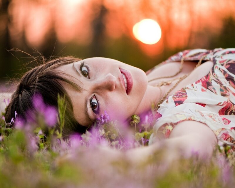 woman lying in flowers at sunset