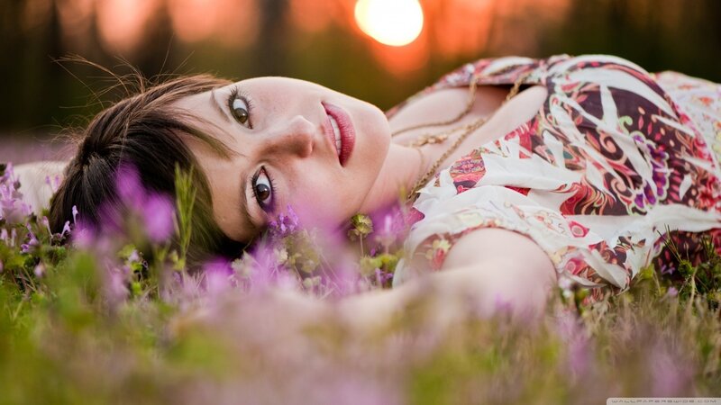 woman lying in flowers at sunset