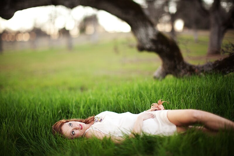 Woman lying in grass at sunset