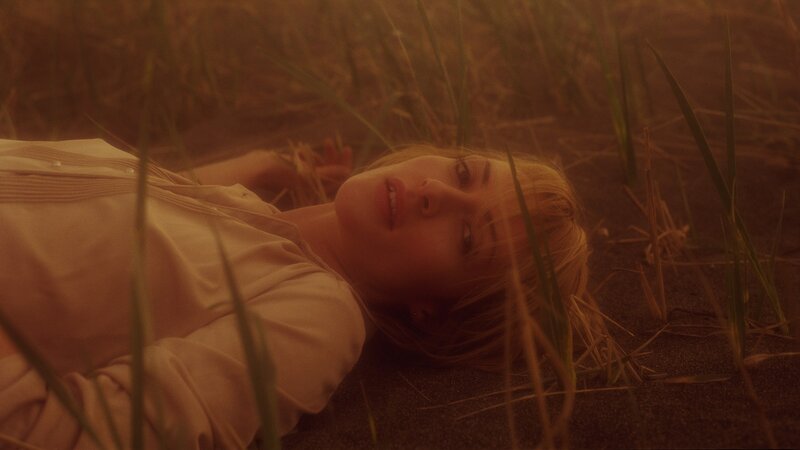 woman lying in grass at sunset