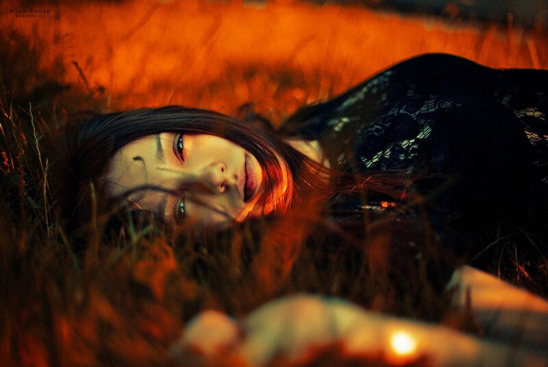 woman lying in grass at sunset