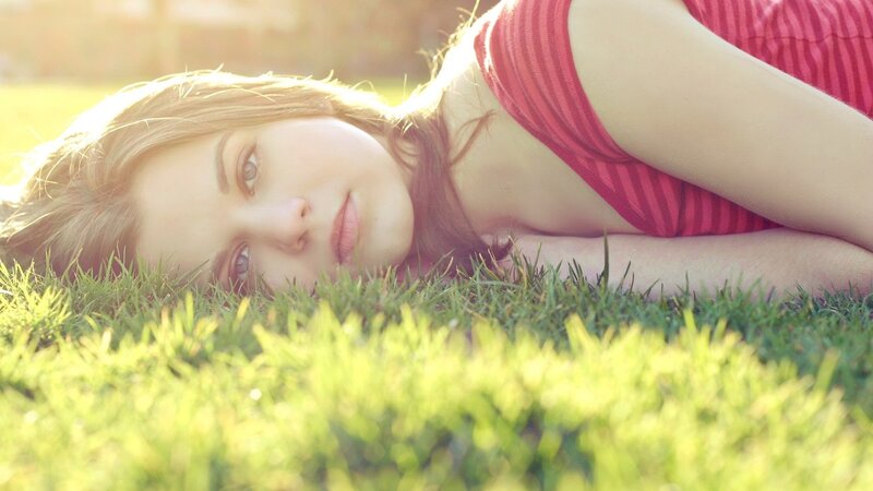 woman lying in grass at sunset