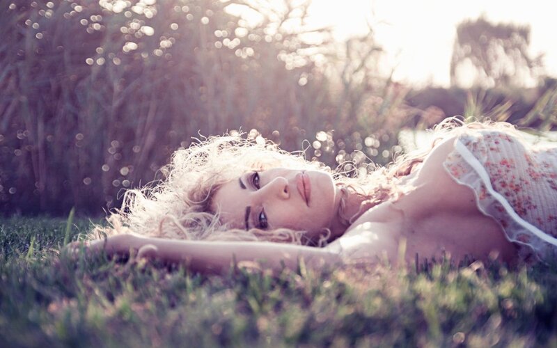 woman lying in grass at sunset