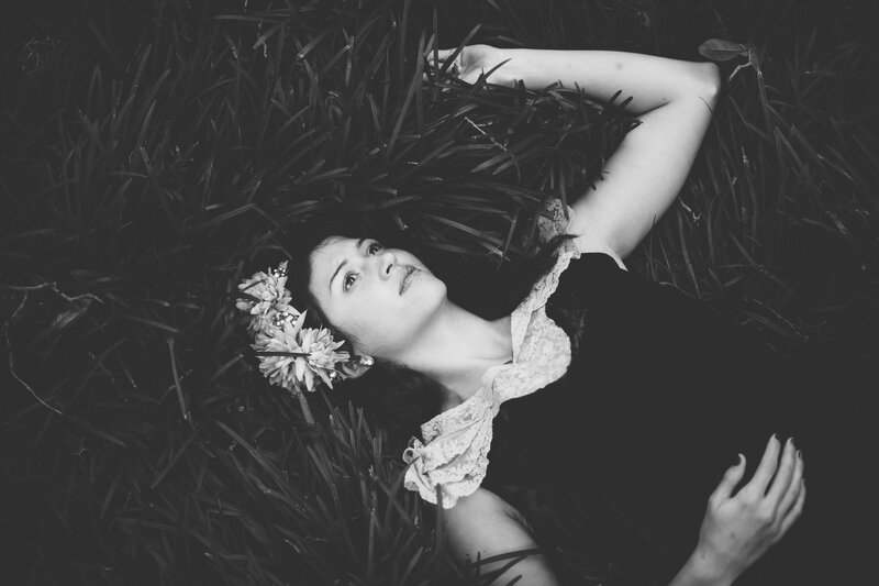 Woman Lying in Grass — Black, Serene, Photograph, Flowers