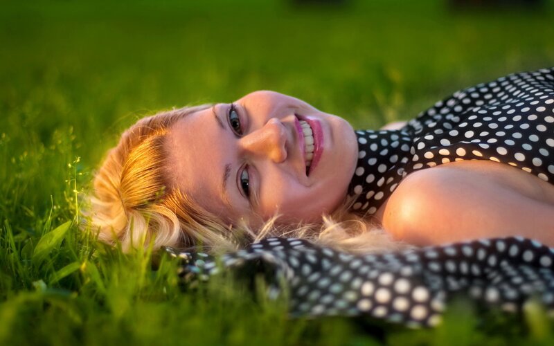 woman lying in grass smiling