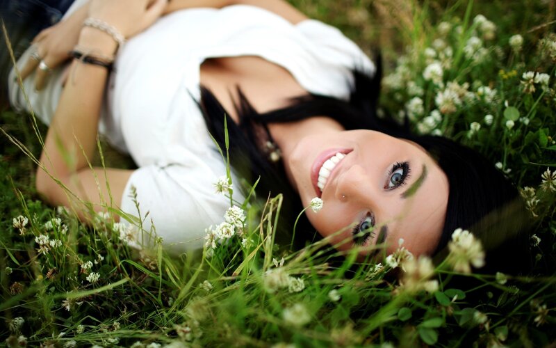 woman lying in grass smiling