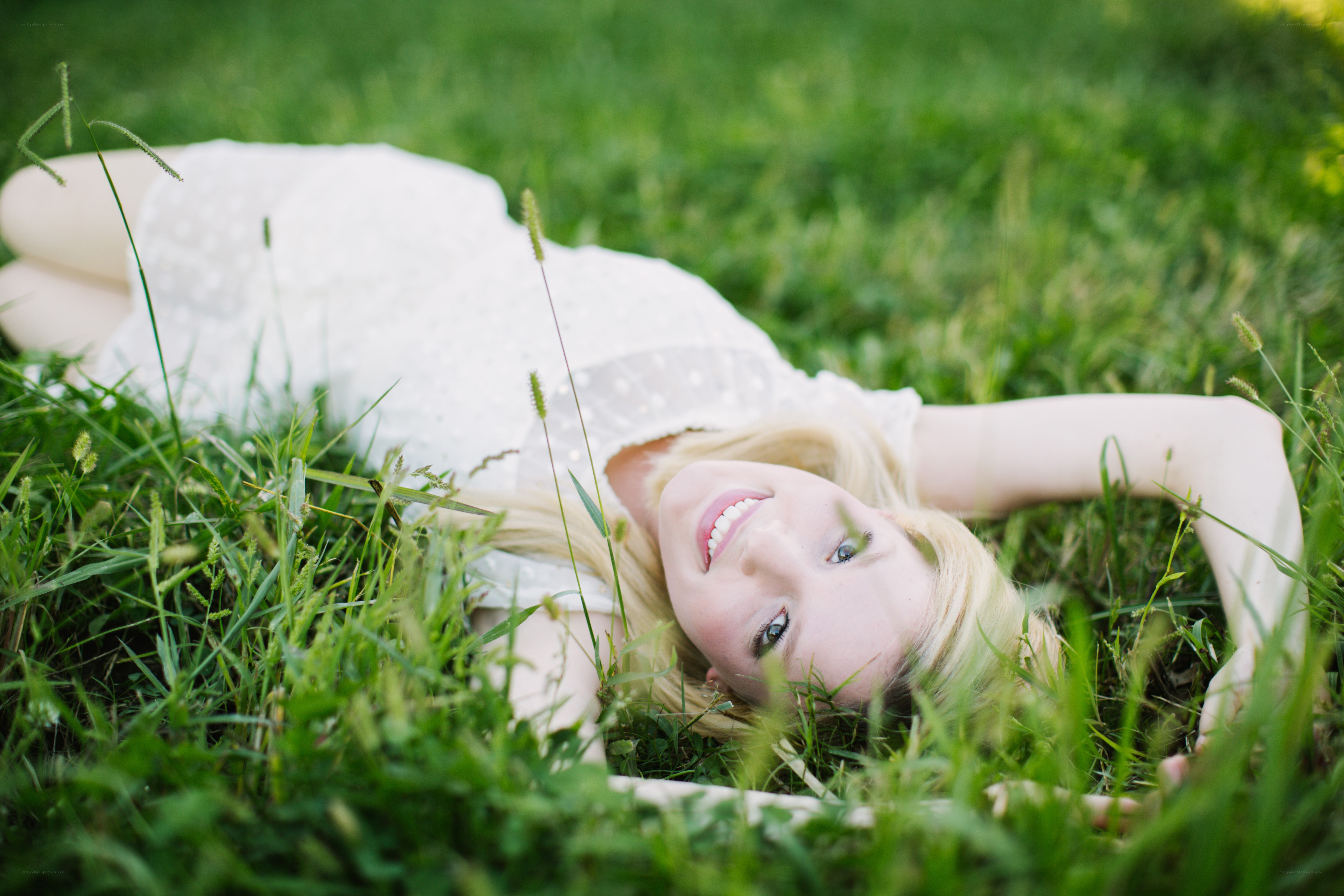 woman lying in grass smiling