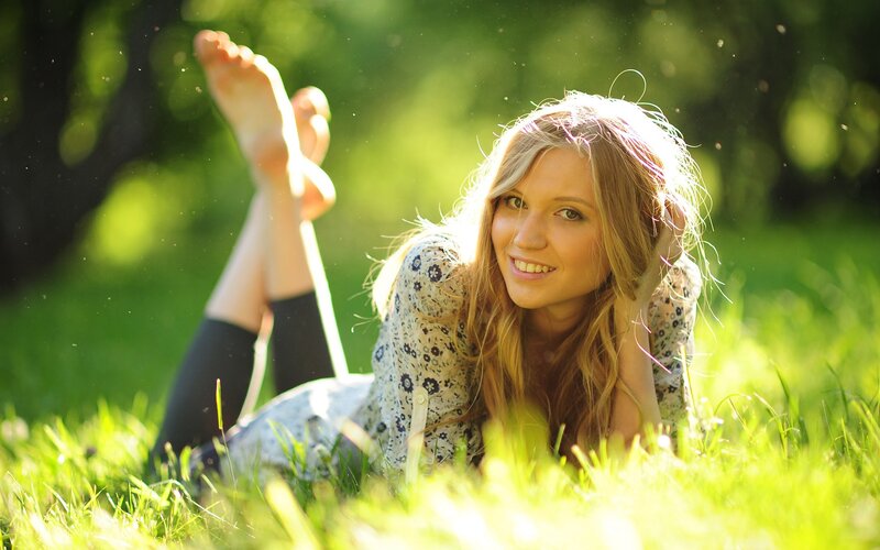 woman lying in grass smiling