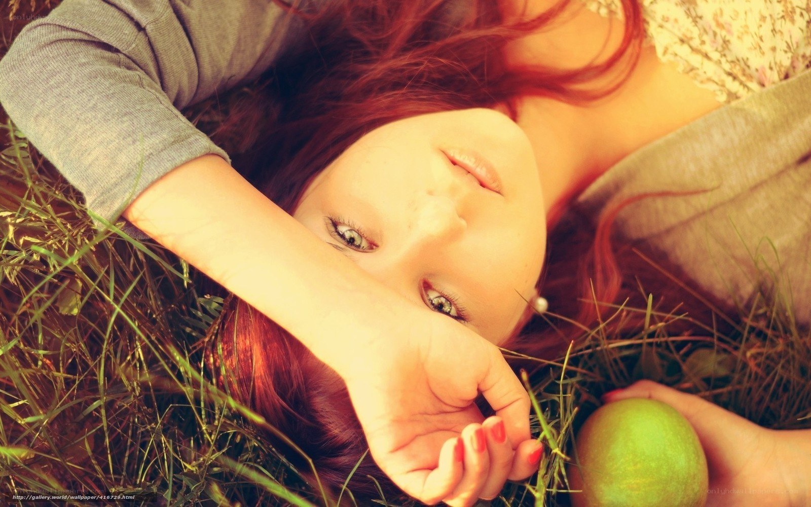 woman lying in grass with apple