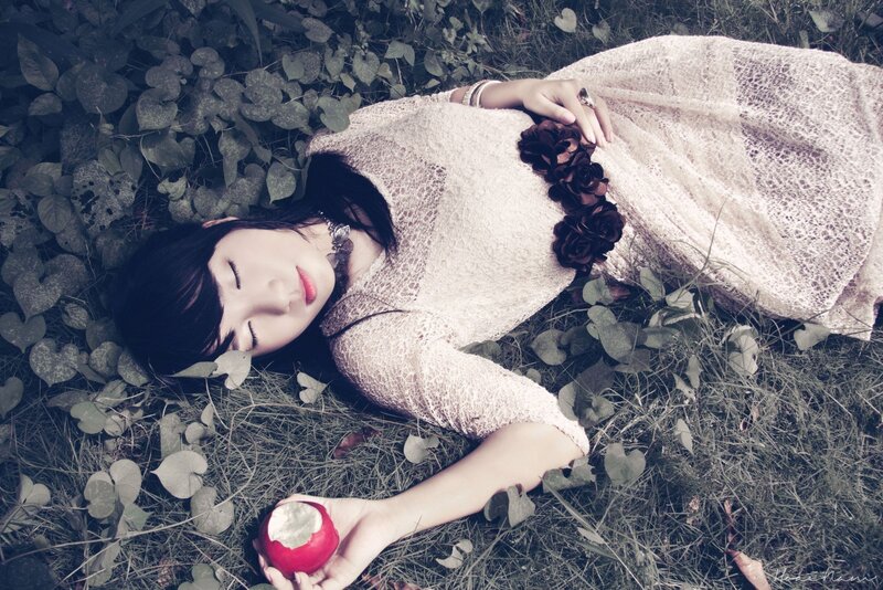 woman lying in grass with apple