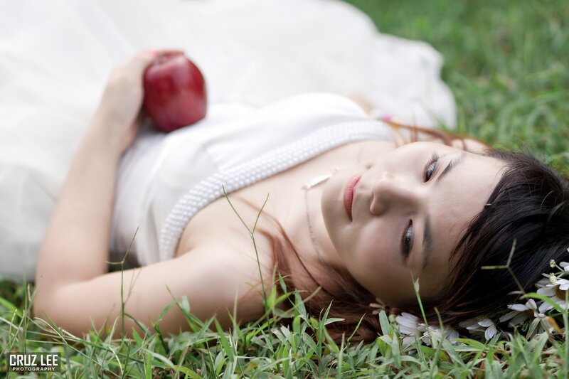 woman lying in grass with apple