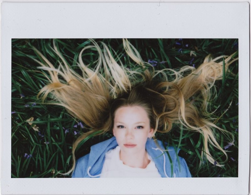 woman lying in grass with blonde hair
