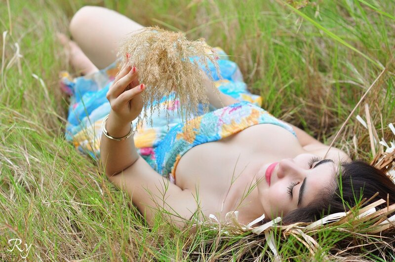 Woman lying in grass with dried plant