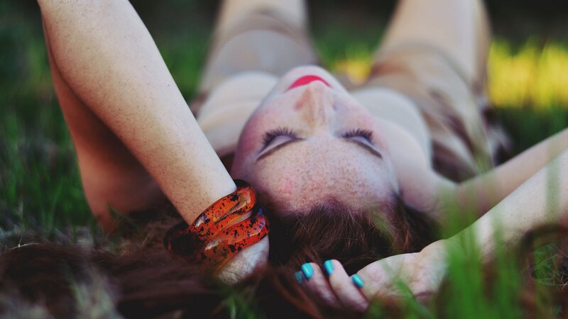 woman lying in grass with eyes closed