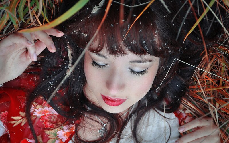 woman lying in grass with eyes closed