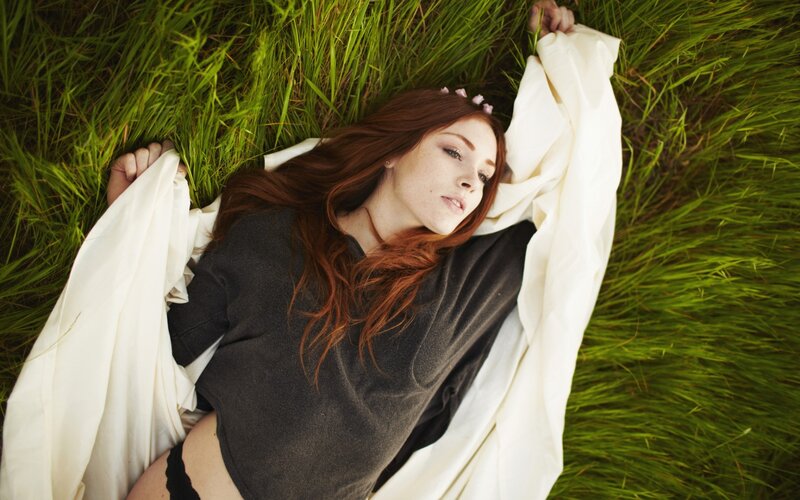 woman lying in grass with flowers