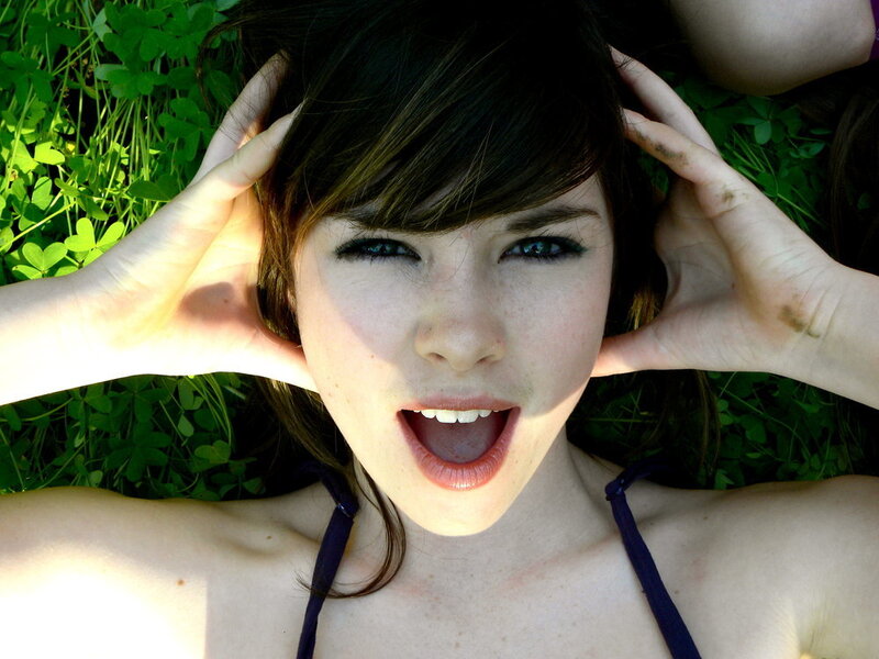 woman lying in grass with hands on head