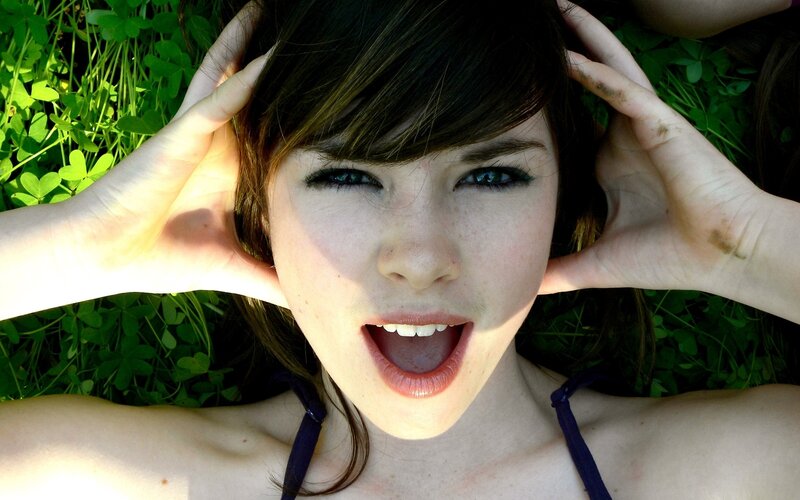 woman lying in grass with hands on head