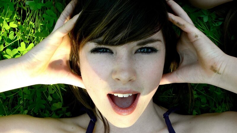 woman lying in grass with hands on head
