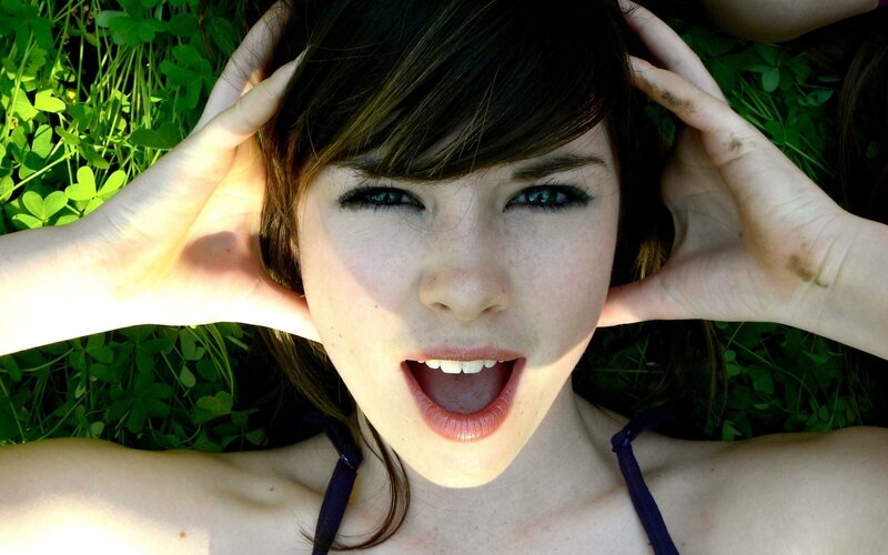 woman lying in grass with hands on head