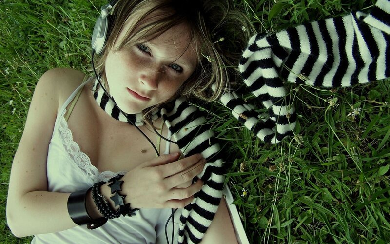 woman lying in grass with headphones