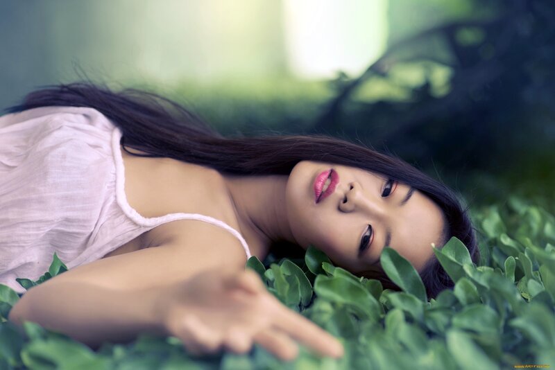 woman lying in green leaves