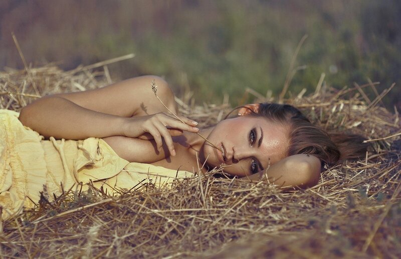 Woman lying in hay field