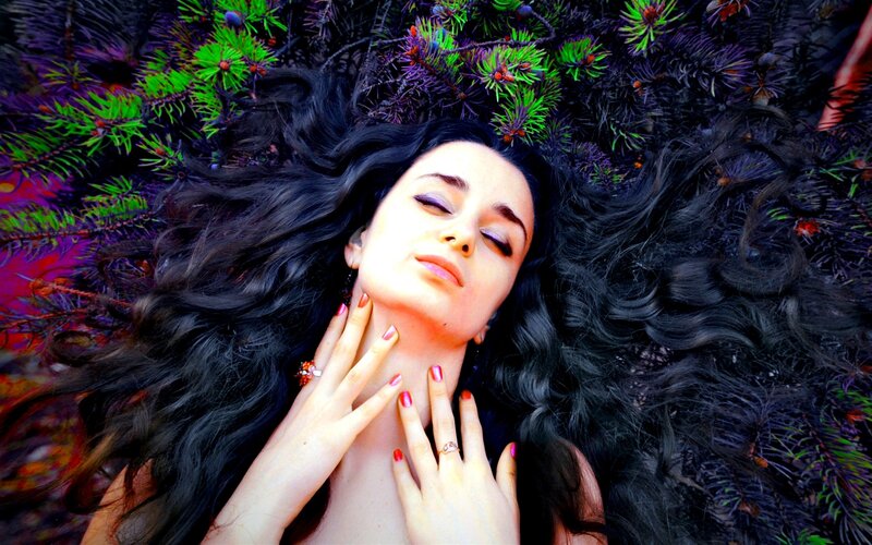 woman lying in pine branches