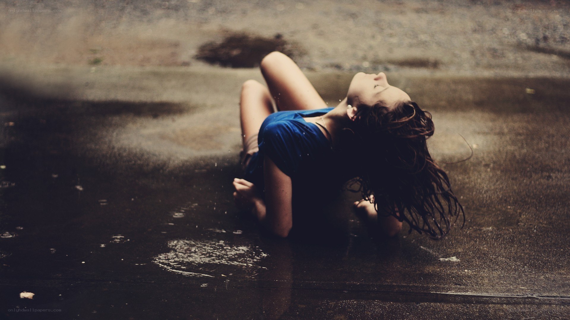 woman lying in rain puddle
