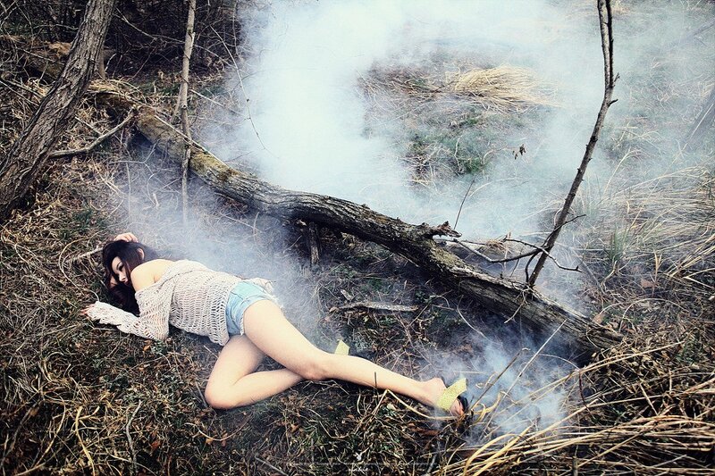 Woman lying in smoky forest