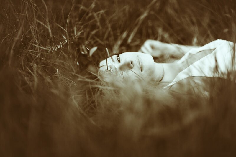woman lying in tall grass