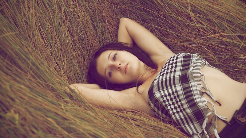 woman lying in tall grass