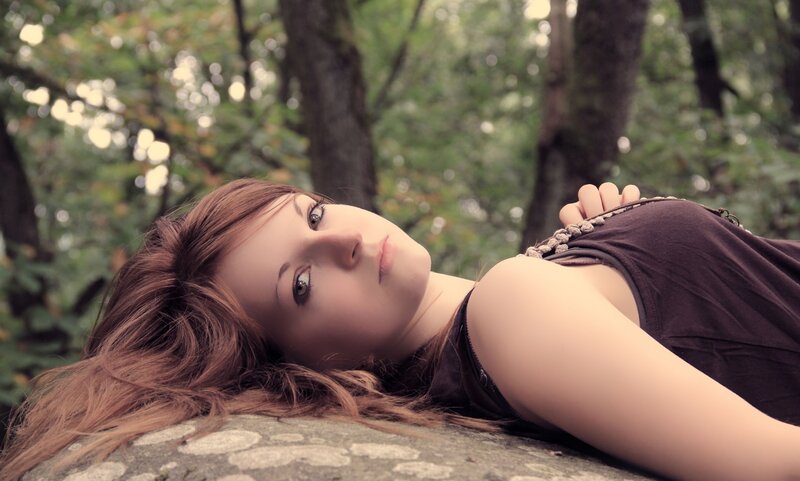woman lying on a rock in forest