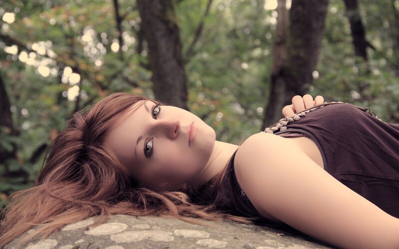 woman lying on a rock in forest